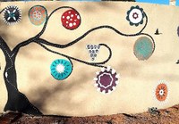 A painting of a tree with colorful circles on the ends of the branches.