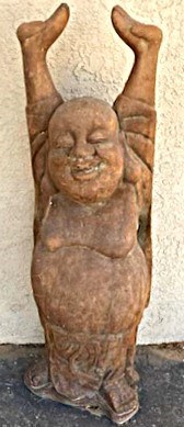 A stone carving sculpture of a Buddha figure standing with his arms outstretched above him.