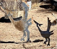 Two metal roadrunner artwork sculptures in the cut-out style, one smaller than the other.