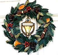A wreath made with evergreen pine leaves, orange slices, and cinnamon sticks.