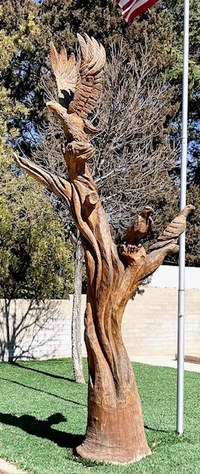 A tree trunk sculpture carving featuring tree eagles.