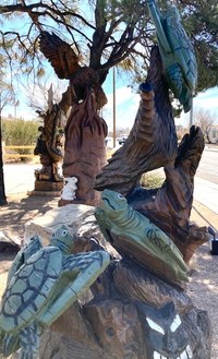 A tree trunk carved sculpture of three sea turtles.