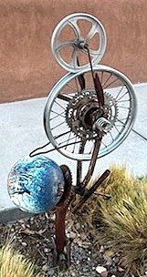 A modern art sculpture made out of various bike parts, including a wheel.
