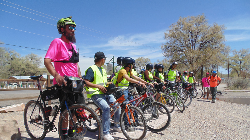 A group of people with bikes lined up outside.