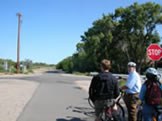A group of people riding bikes on a paved trail.
