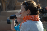 A png of a woman next to a girl who is looking through binoculars.