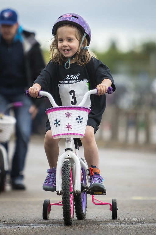 A young girl riding on a bicycle during a bike race.