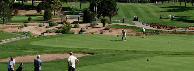 Three groups of people on different parts of a golf course.