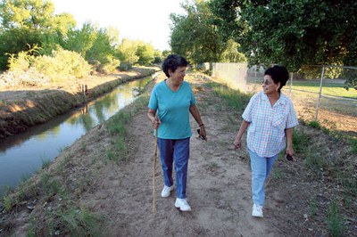Two women walking near the ditch