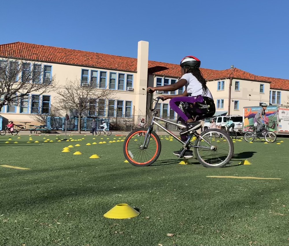 An elementary school student rides a bike through a bicycle safety course.