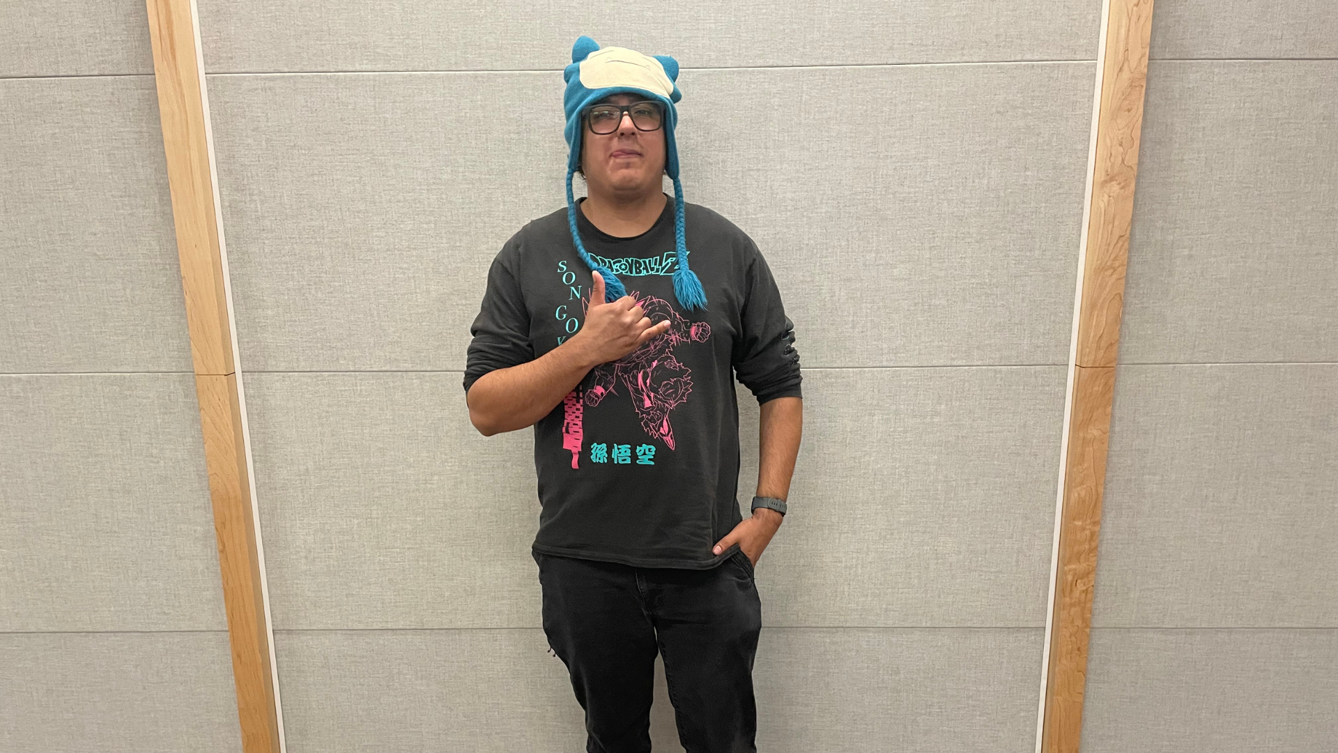 A man with a Melee shirt and glasses, poses for the camera.