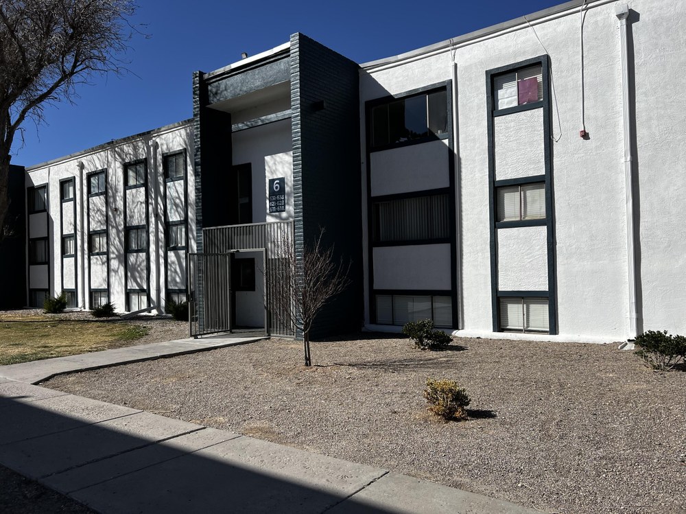 301 Western Skies Dr SE The exterior of a three story apartment complex painted white with with black trim.