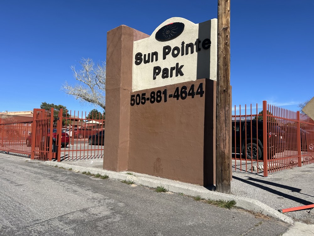 4057 Montgomery Blvd NE A brown and tan sign that reads, "Sun Pointe Park" mounted outside a red fence.