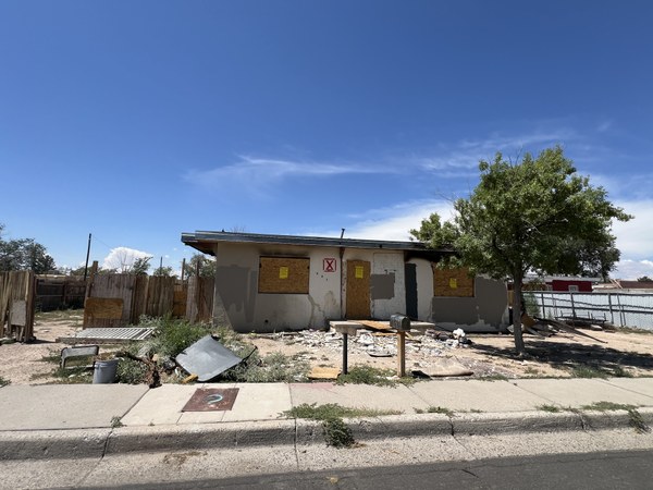 A dilapidated adobe house in need of repair.