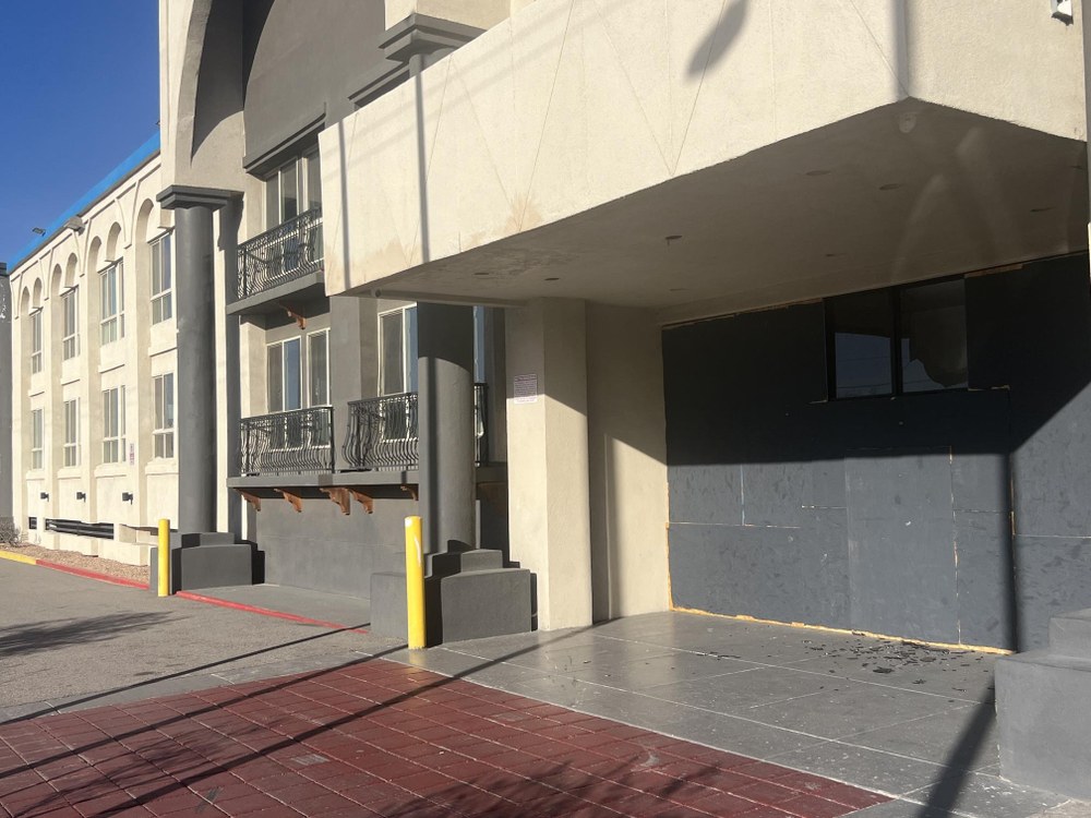 900 Louisiana Blvd NE An adobe finished two-story hotel with boards covering the entryway.