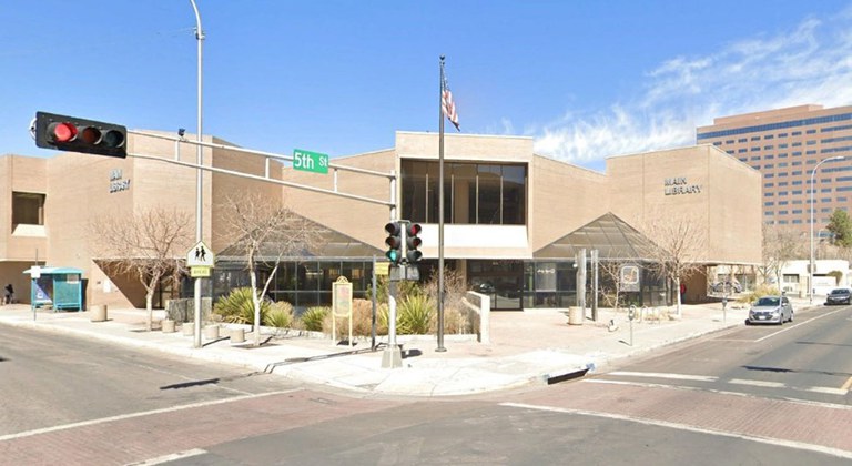 A corner lot with a tan building and large windows.