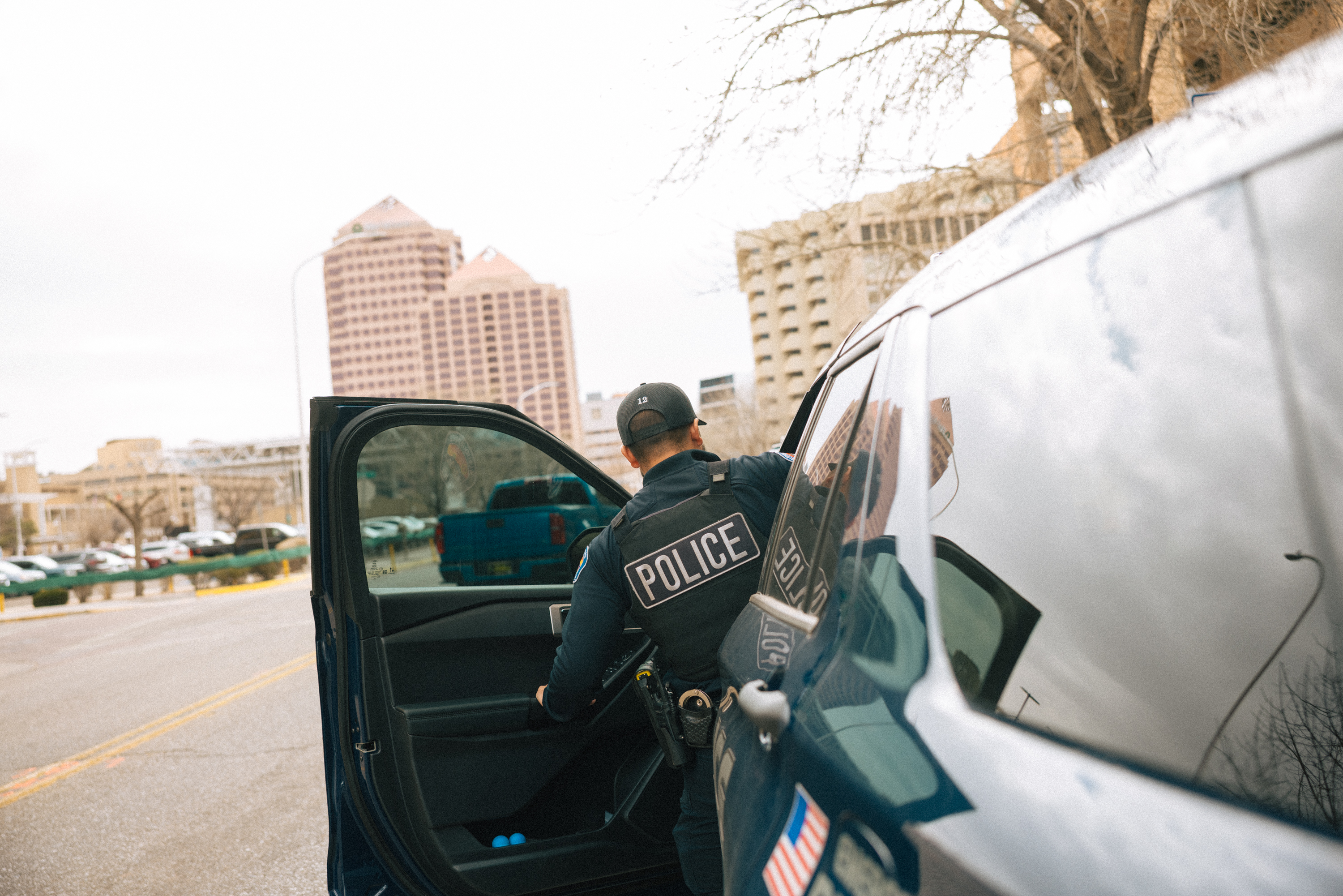 A police office getting into a patrol vehicle.