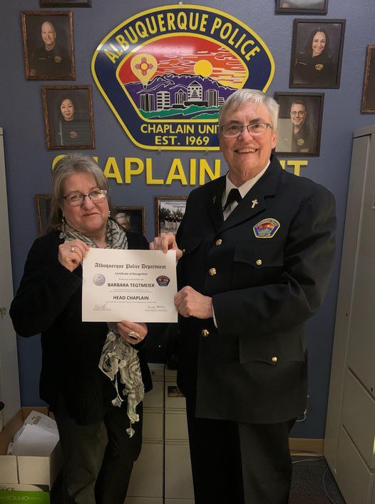 Chaplain Barb holds up certificate becoming head chaplain for APD