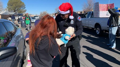 Officer handing toy to child 