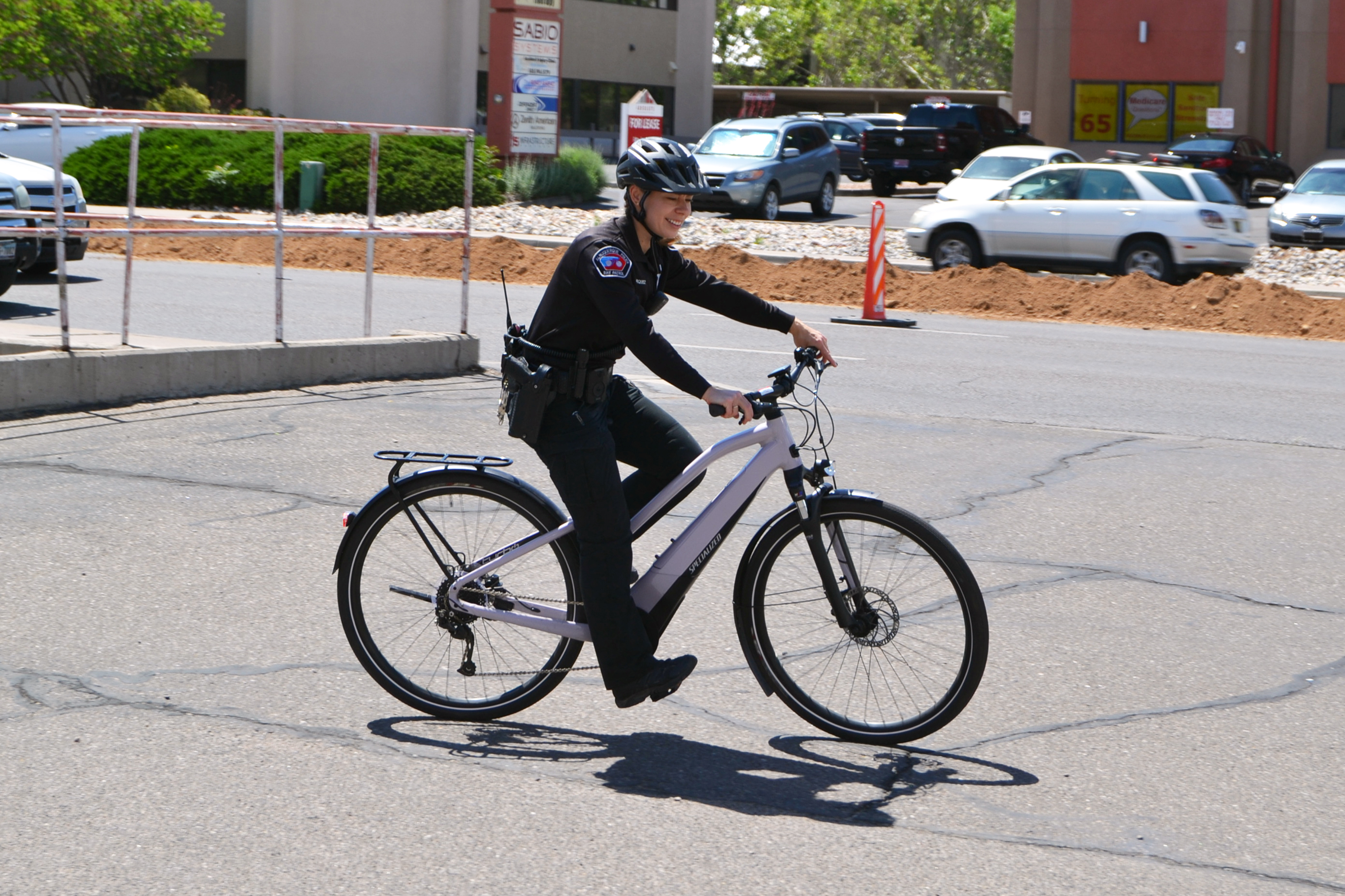 An APD officer riding a bike in a parking lot.