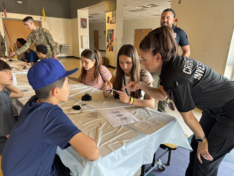 Crime Scene Investigator shows campers how to dust for fingerprints. 