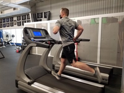 A jpg of an APD officer running on a treadmill at a gym.