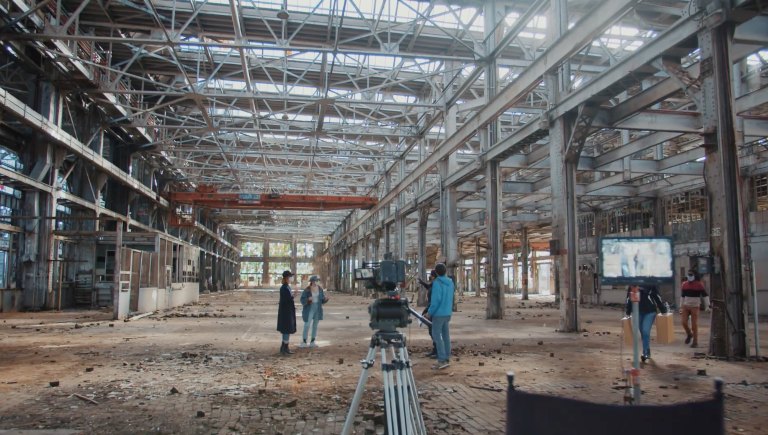 A camera crew filming a scene inside the rail yards.