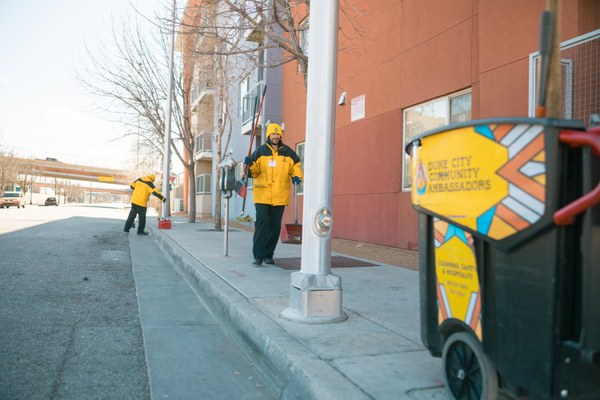 Two Duke City Ambassadors cleaning a sidewalk in downtown Albuquerque.
