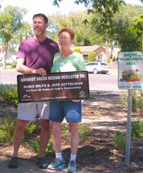 Two Adopt-A-Median volunteers posing with their new sign