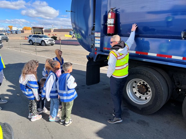 SWMD Field Trip A Solid Waste worker explains how a trash truck works to a group of elementary students.