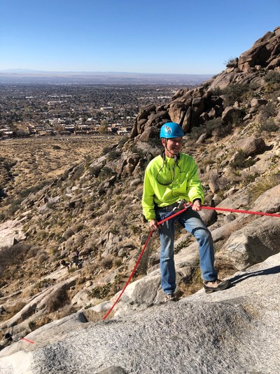 Chuck Malagodi rappelling on a mountain.