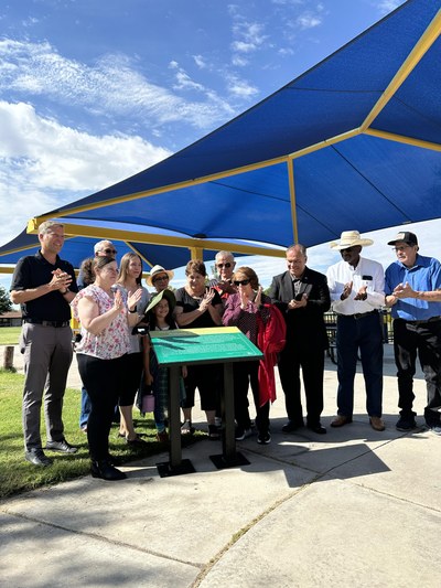 Family of Delano García and officials stand in front of dedication plaque.