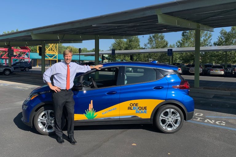 A photo of Mayor Keller with an electric vehicle