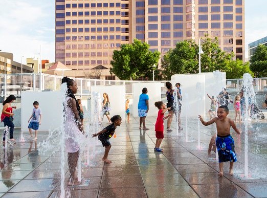 kids playing in downtown cooling center fountain