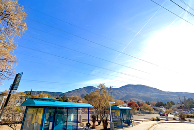 Two blue shelters around 2 benches with a light between them.
