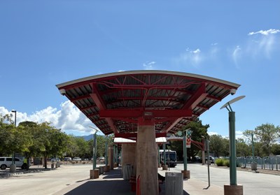 An ART Bus pulling up to covered benches at the Uptown Transit Center in Albuquerque.