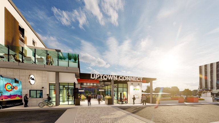 Front facing image of Uptown Connect's main entrance at the Transit Plaza with a bus passing by.