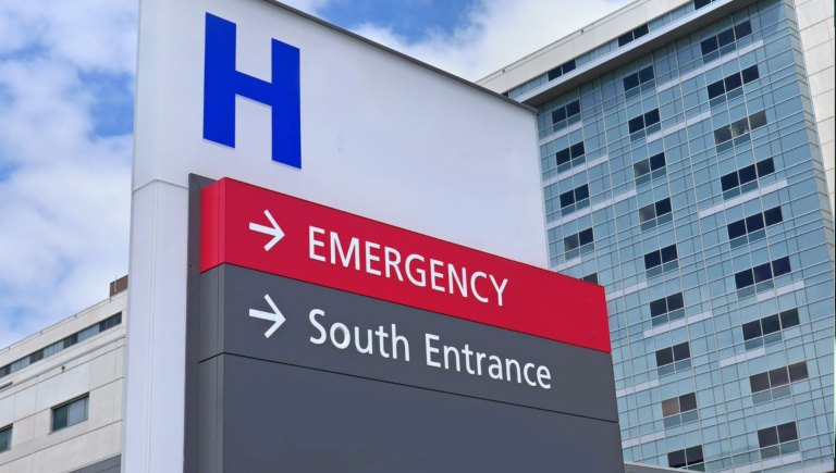 Signs pointing towards the Emergency Room outside of a hospital