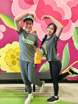 Two teens posing in front of a floral backdrop.